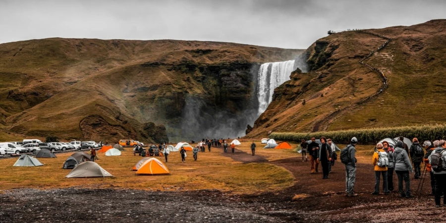 Personas paradas en un camping cerca de las cascadas