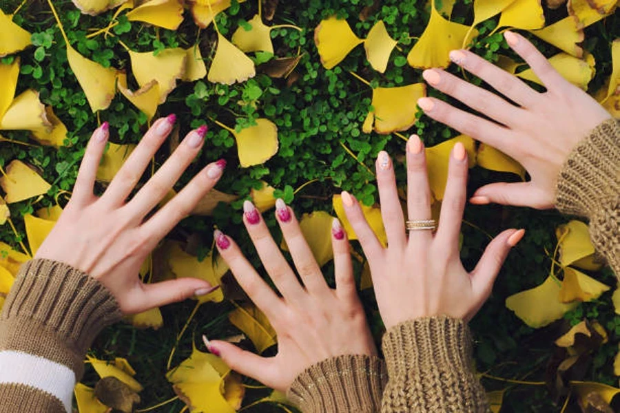 Two pairs of hands with different colors of fall nails