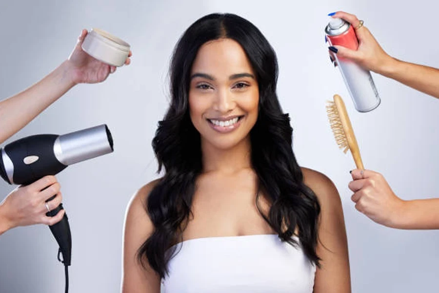 Mujer de pie en el estudio con una selección de productos y equipos para el cabello