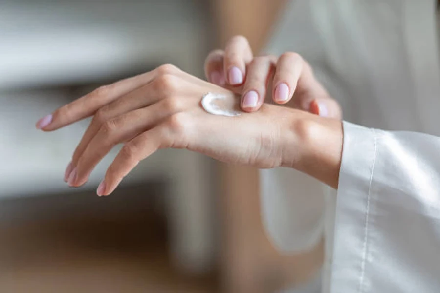 Mujer usando crema humectante para manos en casa