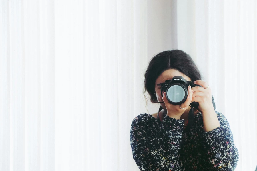 Woman in Black Long-sleeved Shirt Using Camera