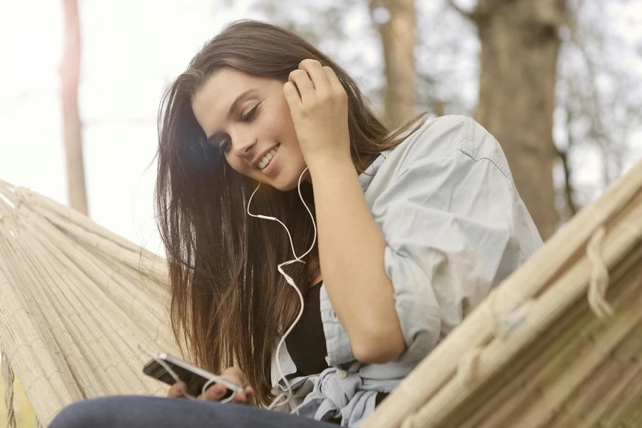 Mulher em camisa branca de botões enquanto ouve música