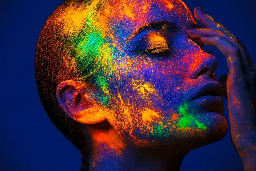 Femme posant avec de la poudre de maquillage fluo