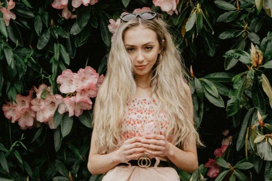 Mujer de pie frente a flores