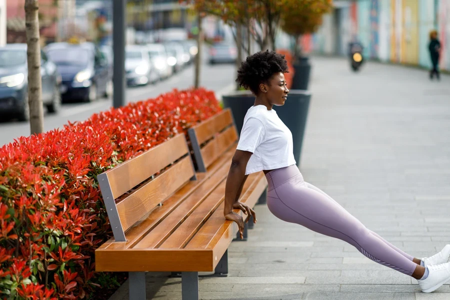 Frau macht Dehnübungen mit rosa Crossover-Leggings