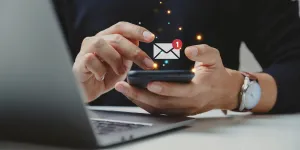 Un hombre de negocios revisando un correo electrónico en su teléfono.