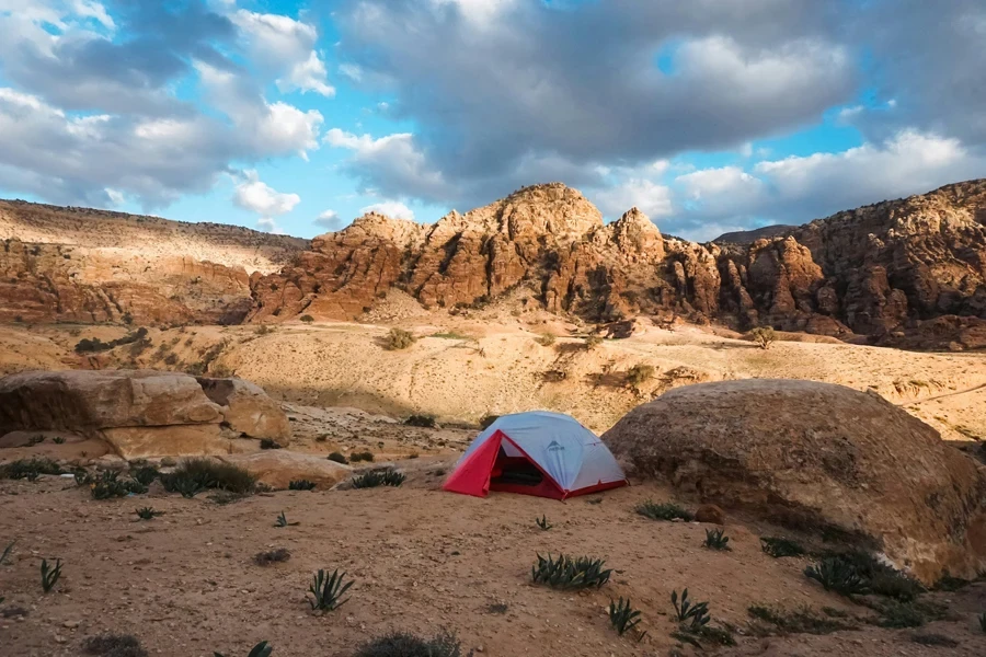 Una tienda de campaña roja y blanca situada en lo alto de un desierto.