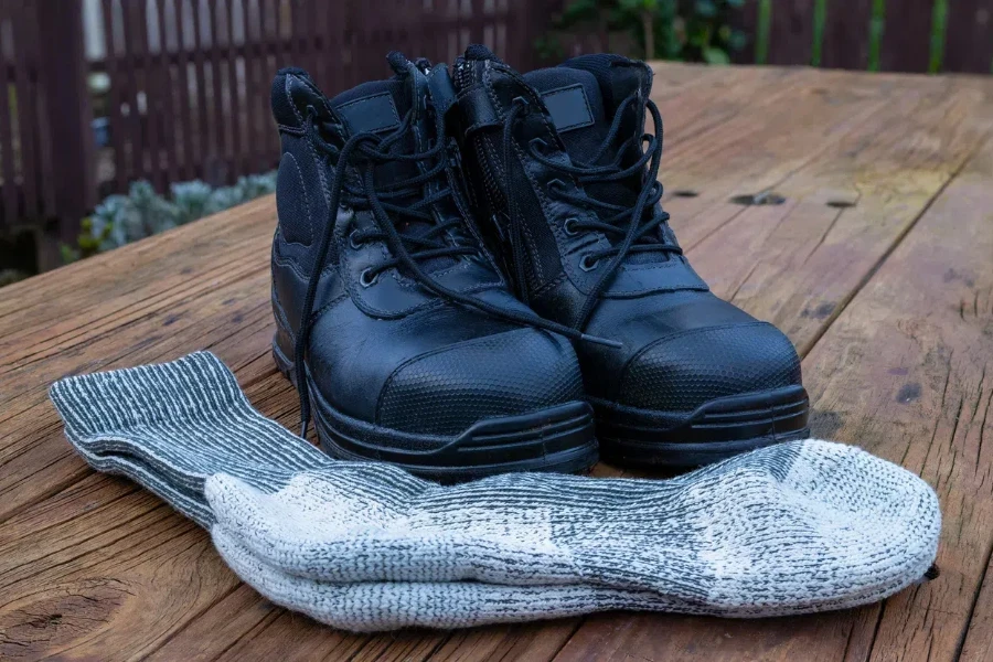 Black pair of boots and woolen snug boots socks