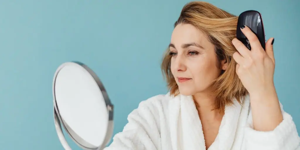 Woman checking out her hair in a small mirror