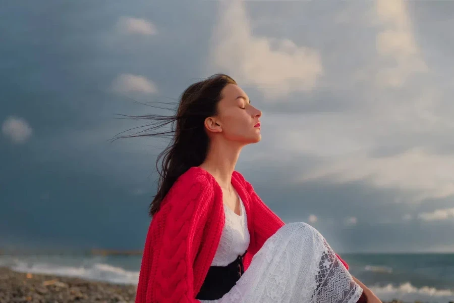 Woman in a red cardigan enjoying the sunset