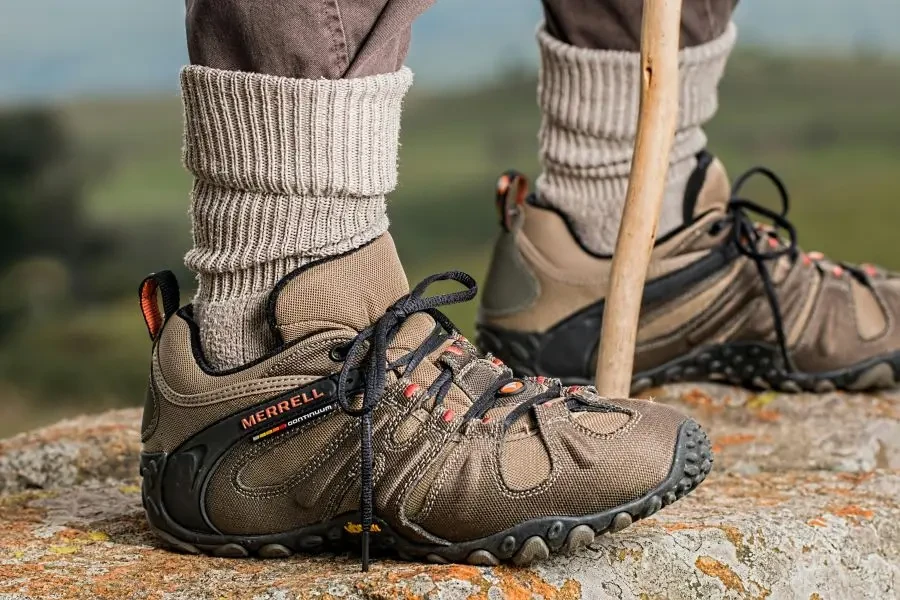 Hiking boots by Merrell on a rock edge, featuring outdoor adventure gear