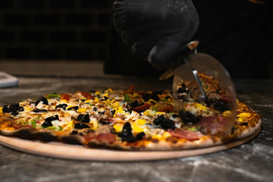 A Person Slicing a Pizza