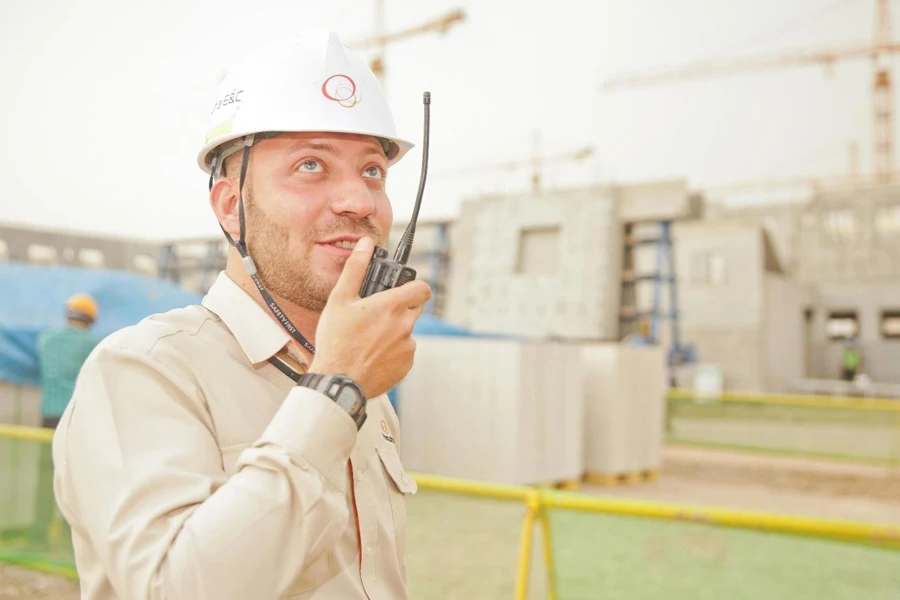 Una persona con un casco che parla al walkie-talkie