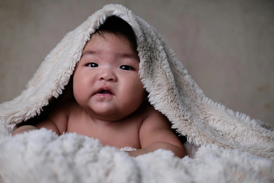 Bambino con asciugamano sopra la testa