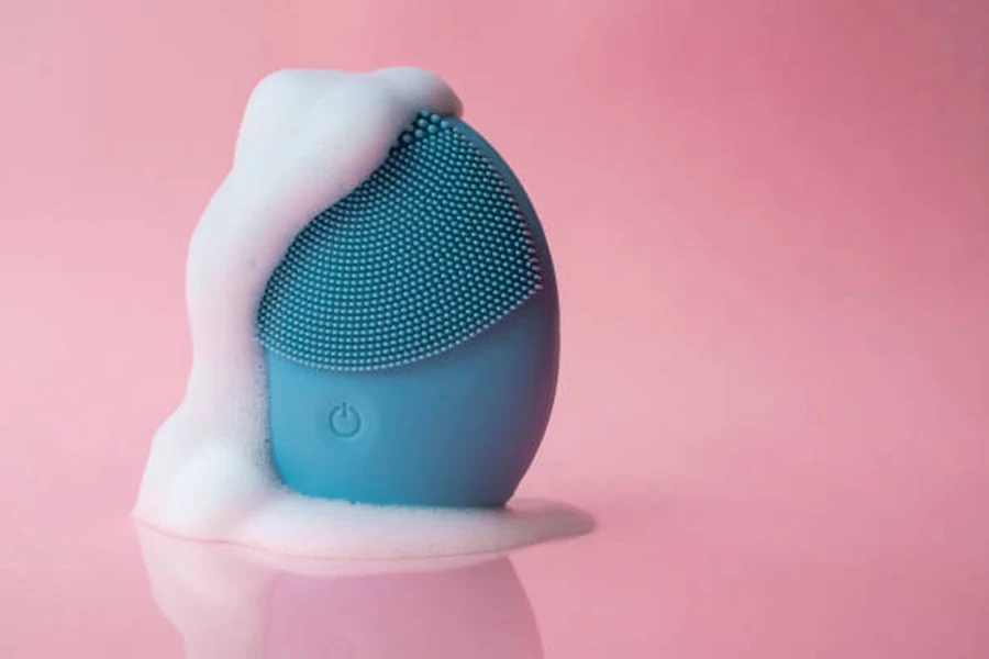 Outil de nettoyage en silicone bleu avec de la mousse de savon qui sort