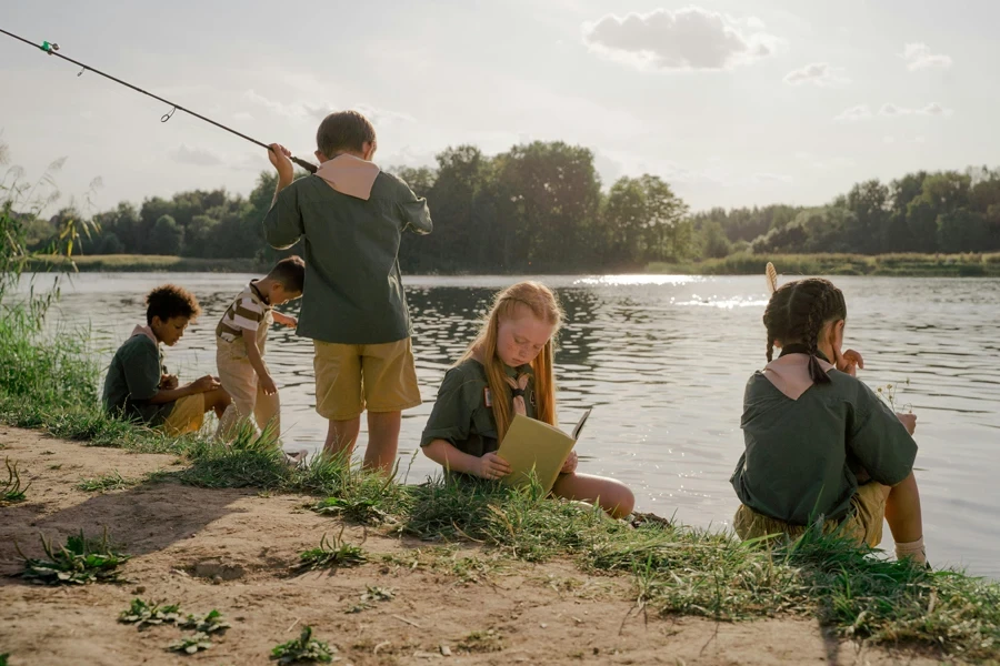 Children Sitting Near Body of Water