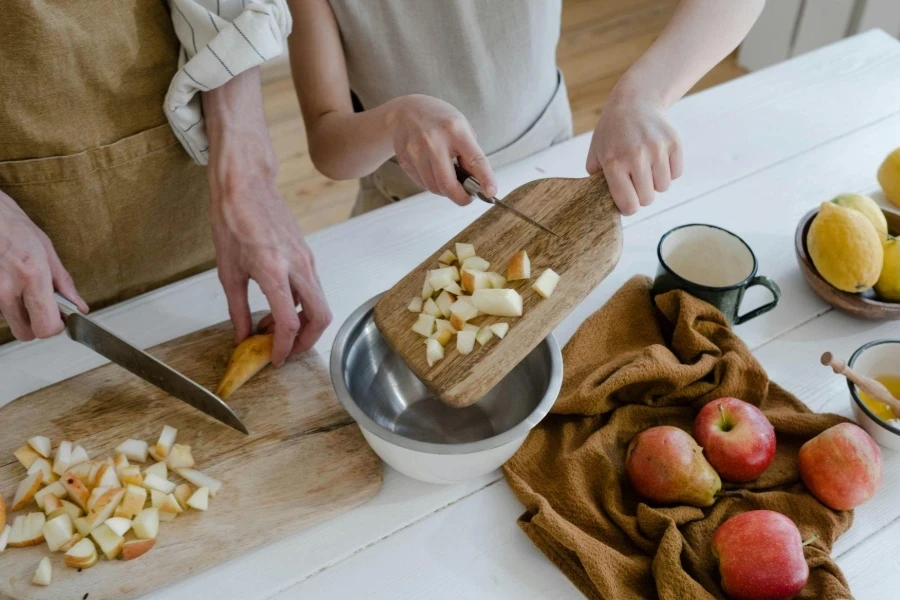 Pai e filha cortando maçãs na cozinha