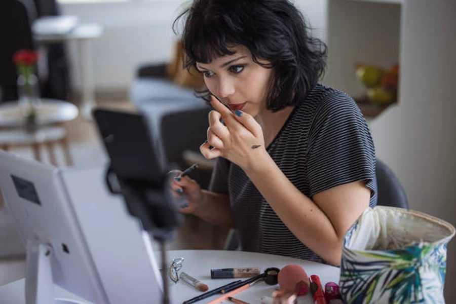 メイクアップのチュートリアルを携帯電話で撮影する女の子