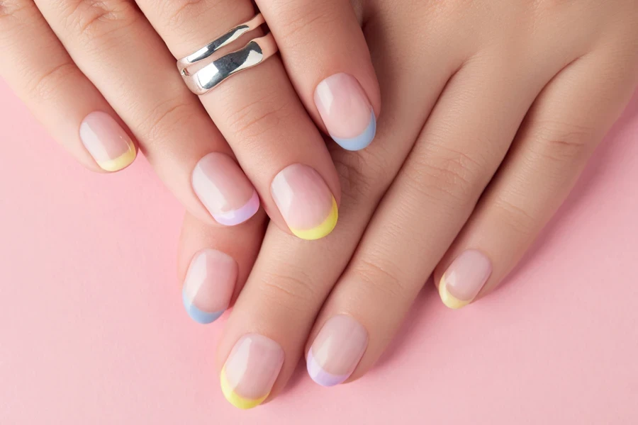 Hand with French manicure with different colored tips