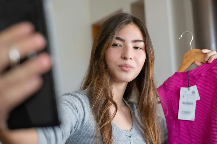 Signora che commercializza una camicetta rosa online