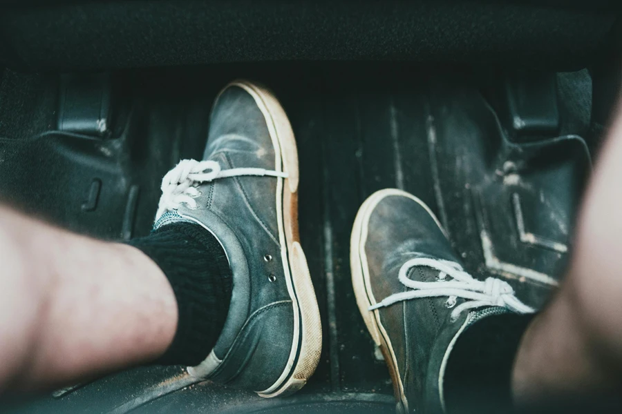 Jambes dans des chaussures dans la voiture