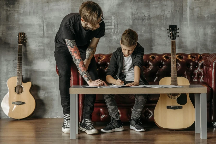 Man Giving a Guitar Lesson to a Boy