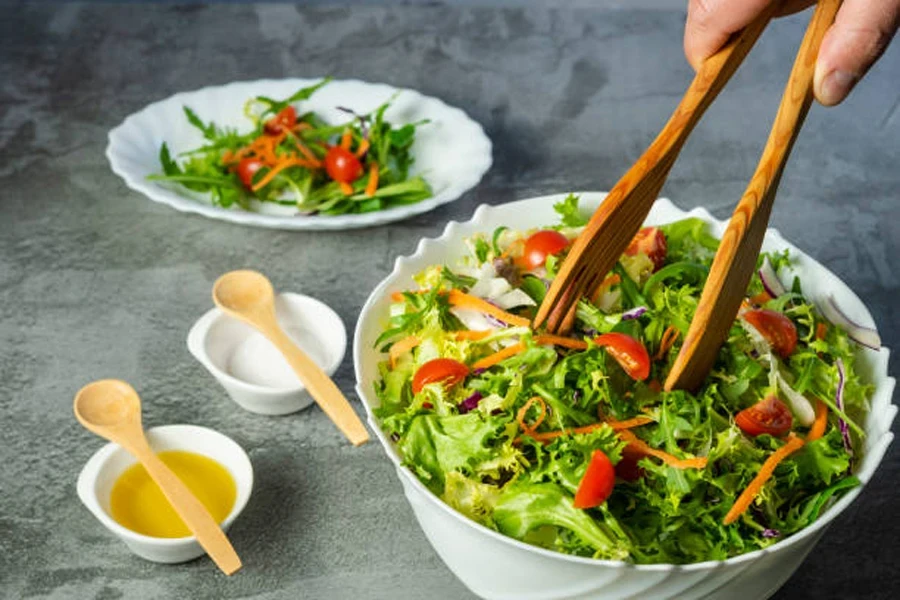 Man's Hand Serving Green and Healthy Salad Plate