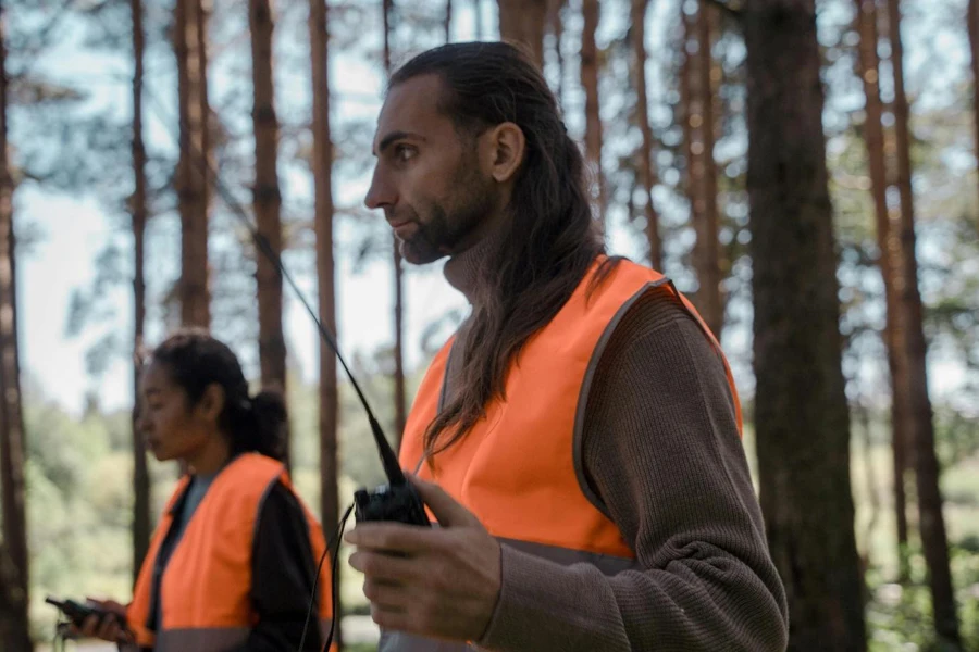 Pessoas em uniforme de jaqueta segurando um walkie talkie