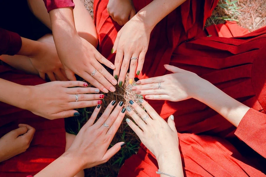 Six hands together comparing nail designs