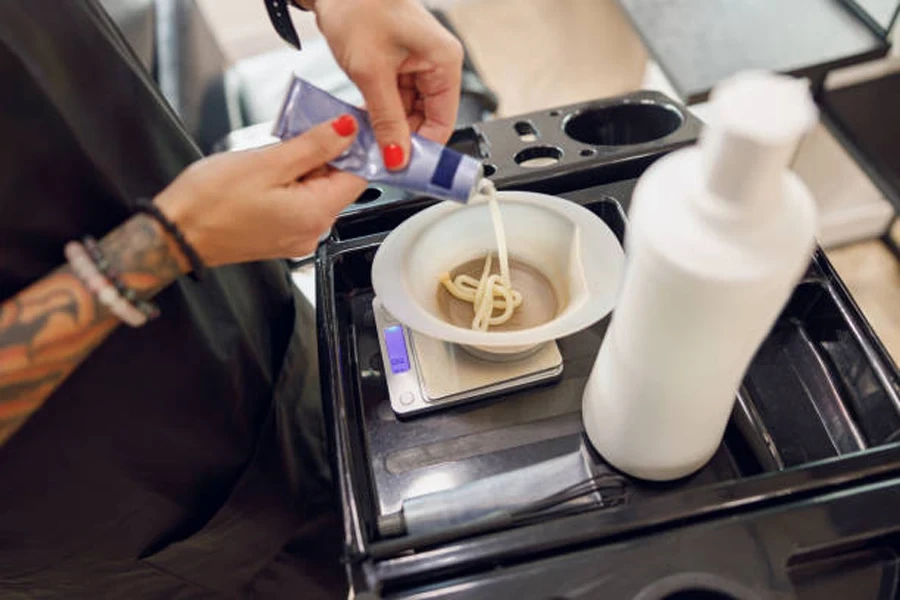 Stilista che prepara una tintura per capelli in un contenitore