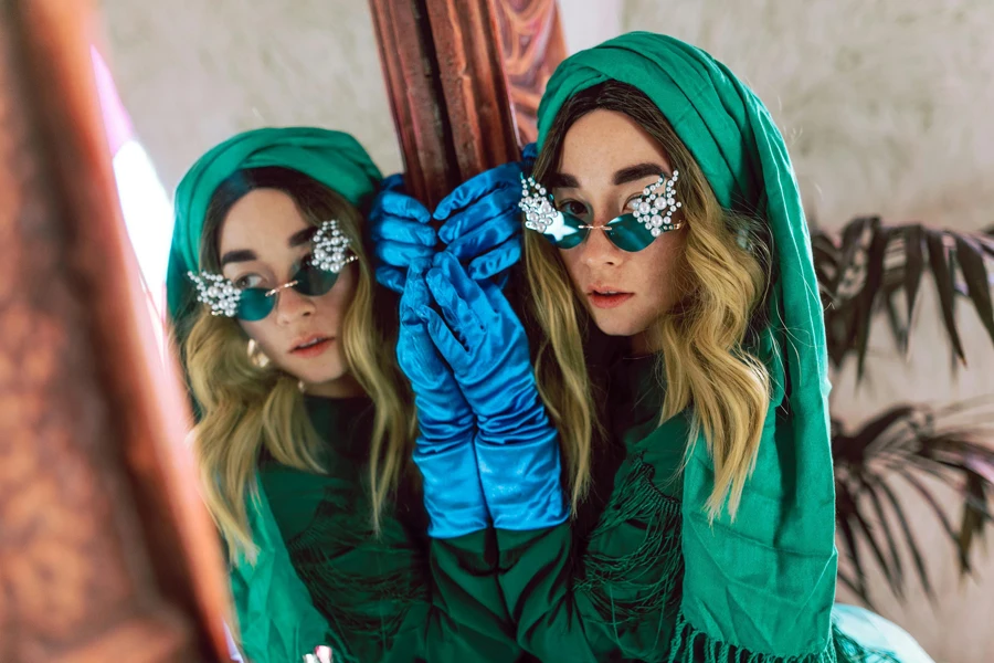 Woman in Green and Blue Zip Up Jacket Wearing Sunglasses