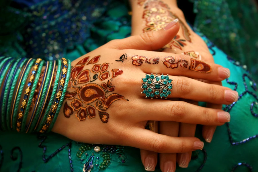 Woman in cultural attire with henna on her hands