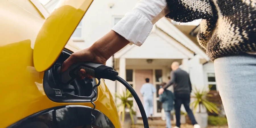 Woman plugging electric charger into car