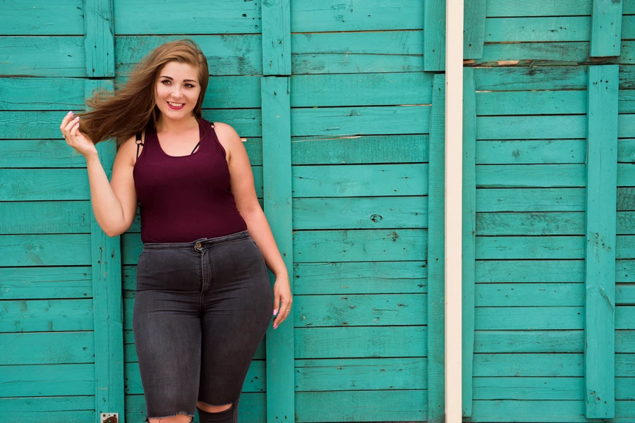 Femme posant dans un jean taille haute déchiré