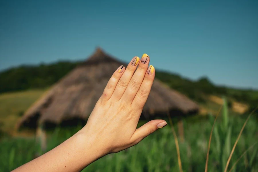 Yellow and black designs over bare nails