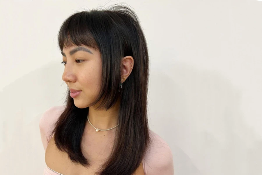 Junge Japanerin mit langen Haaren im Hime-Cut-Stil