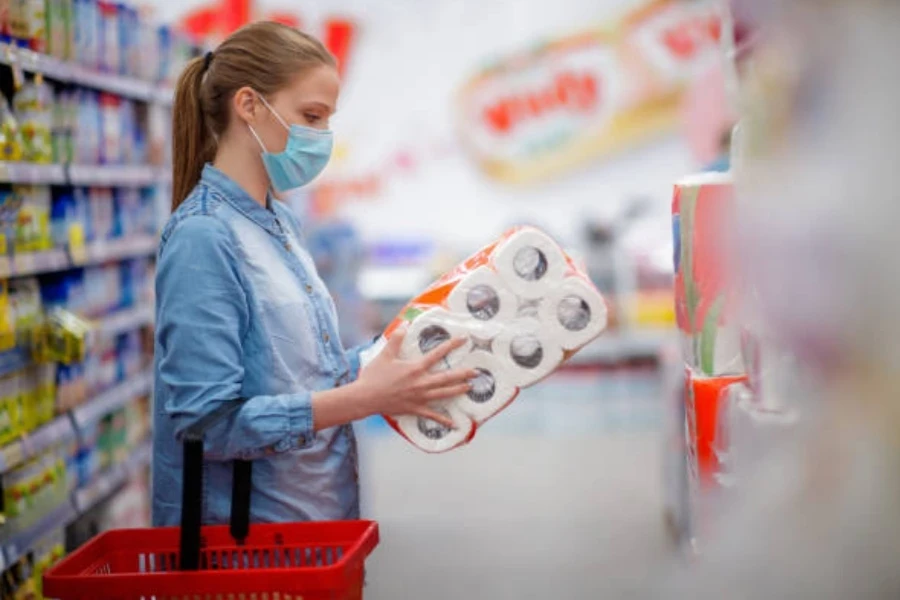 Young Woman Looking at Toilet Paper Pack in Store