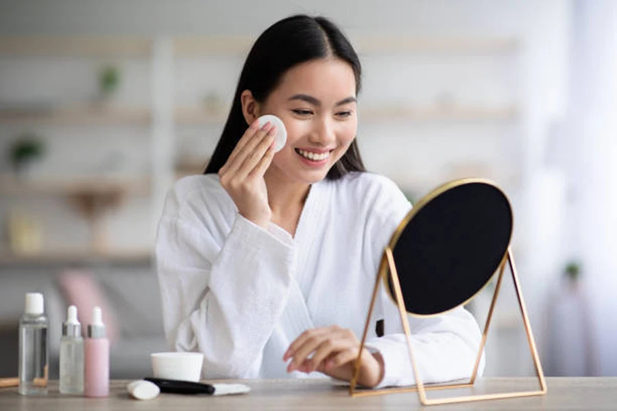 Jeune femme devant un petit miroir enlevant le mascara tenace