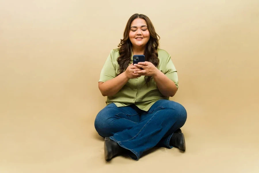 Una mujer con curvas sentada con jeans acampanados