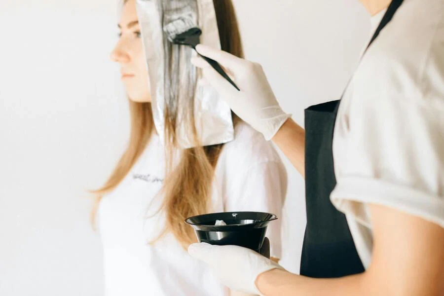 un coiffeur qui colore les cheveux d'une femme