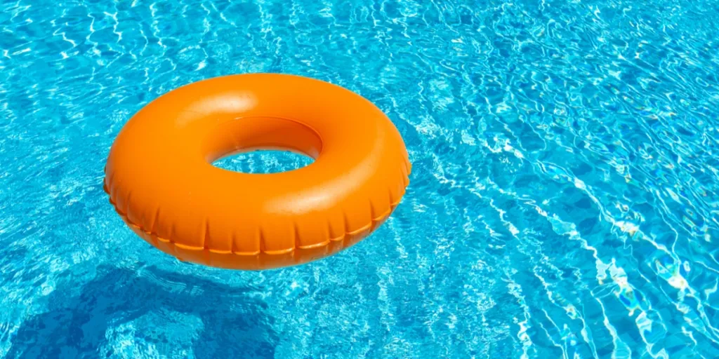 ein orangefarbener Poolring auf dem Wasser