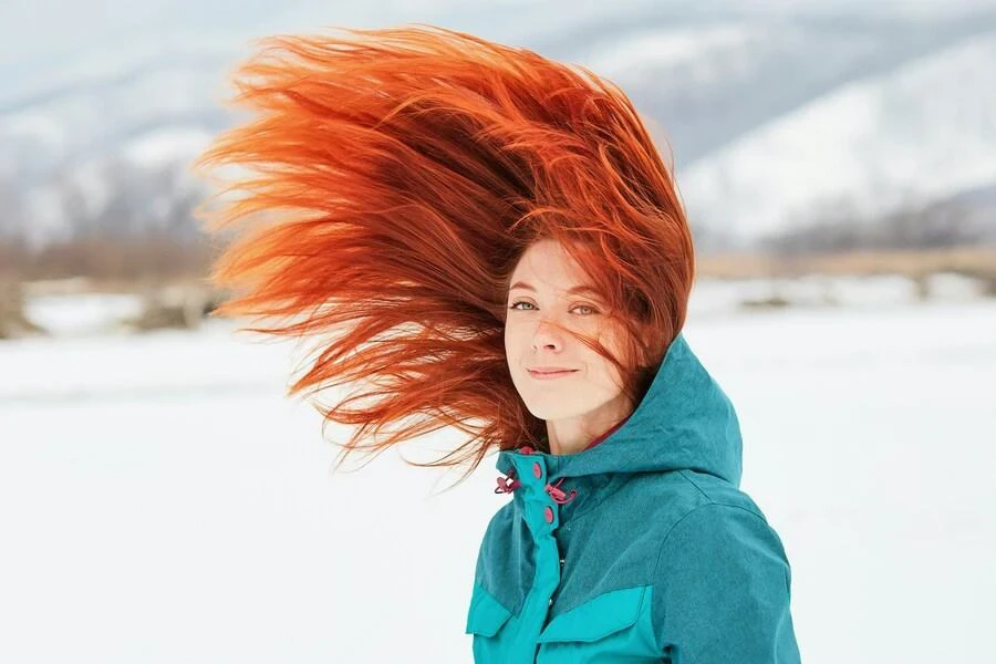 femme dans la neige avec les cheveux flottants