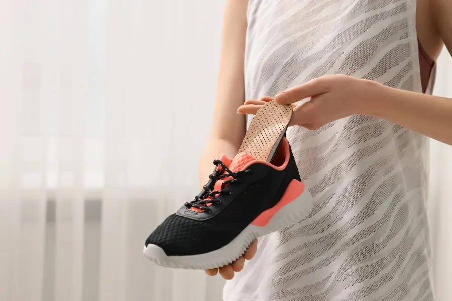 Woman putting orthopedic insole into shoe