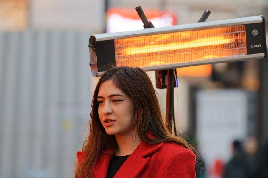 Una ragazza in piedi sotto un termosifone