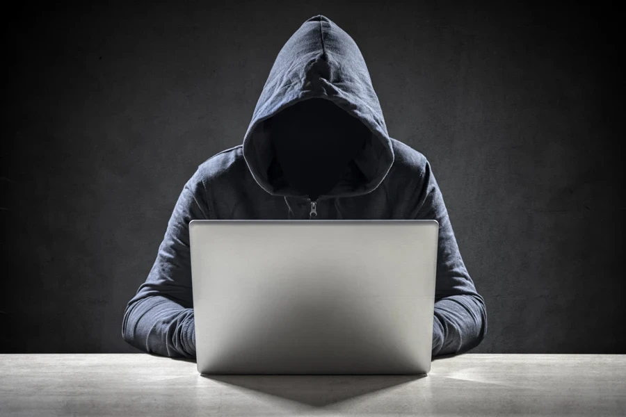 A hacker in a hoodie trying to scam victims