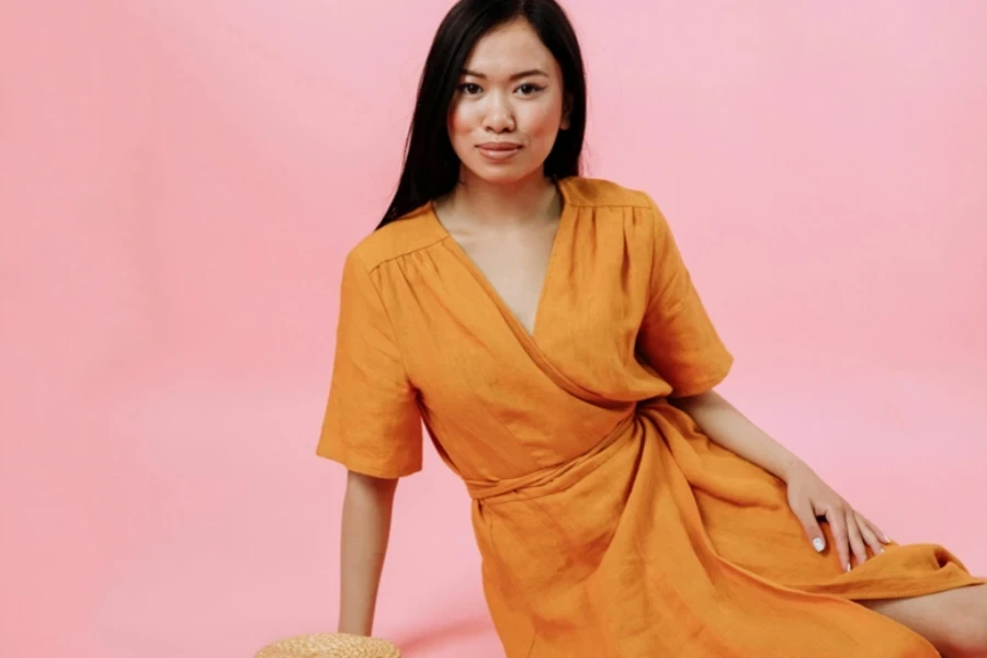 A lady wearing an orange wrap dress