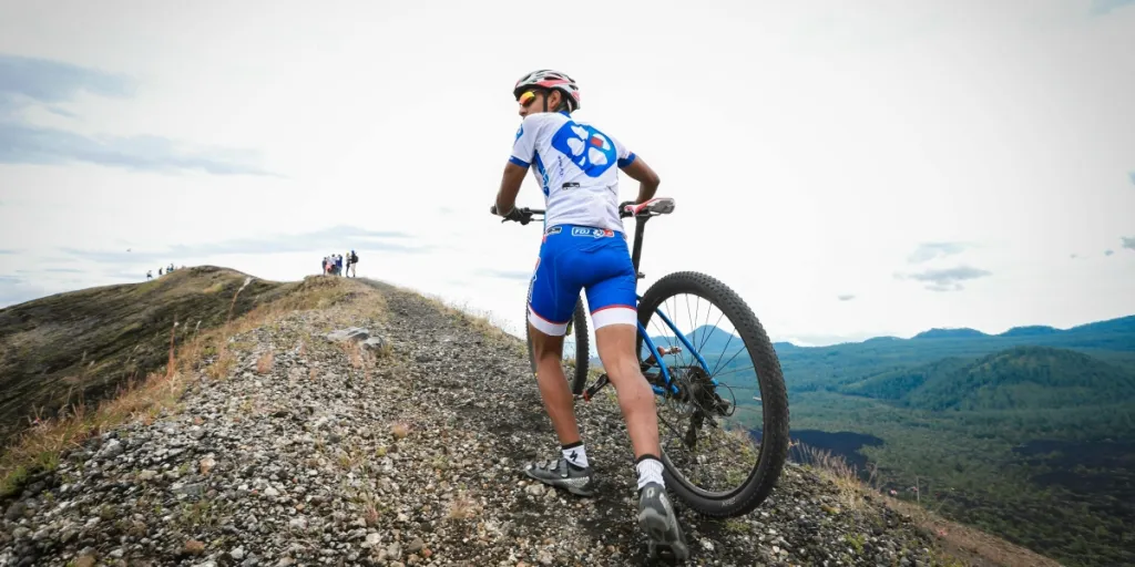 Un ciclista di montagna in tenuta da ciclista scala un sentiero roccioso nel Michoacán, evidenziando l'avventura all'aria aperta e la determinazione