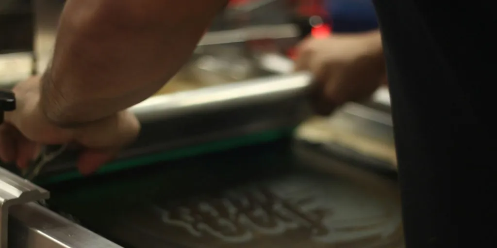 A person working on a screen printer