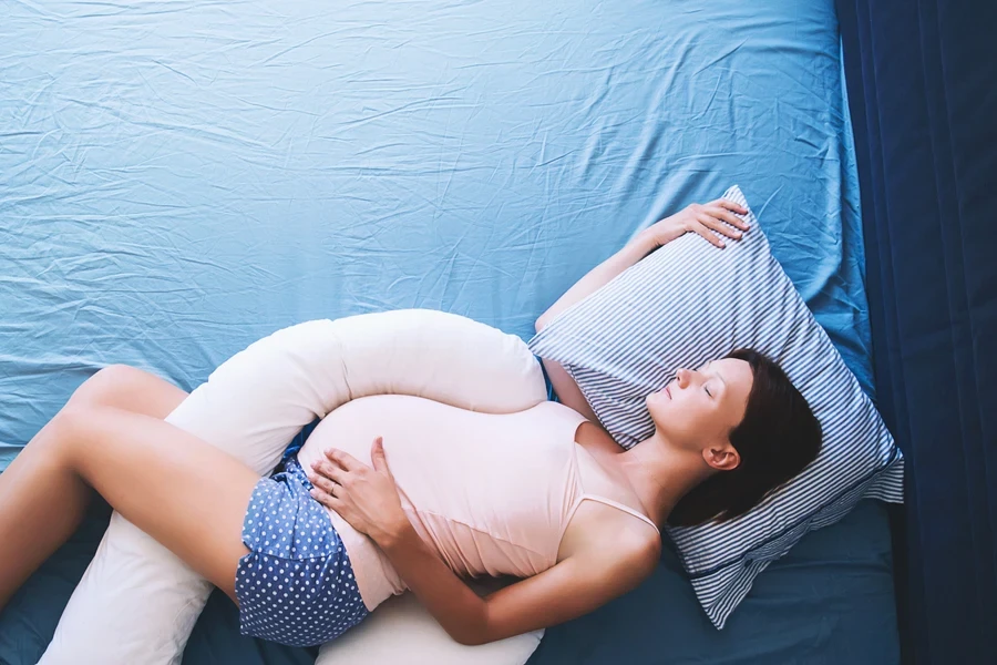 A pregnant woman on her side with a pillow