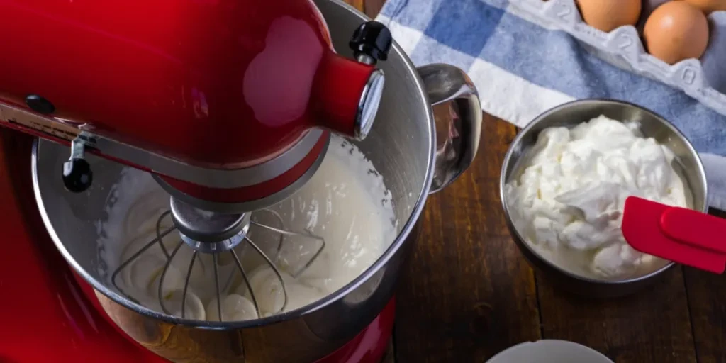 A red stand mixer whipping cream